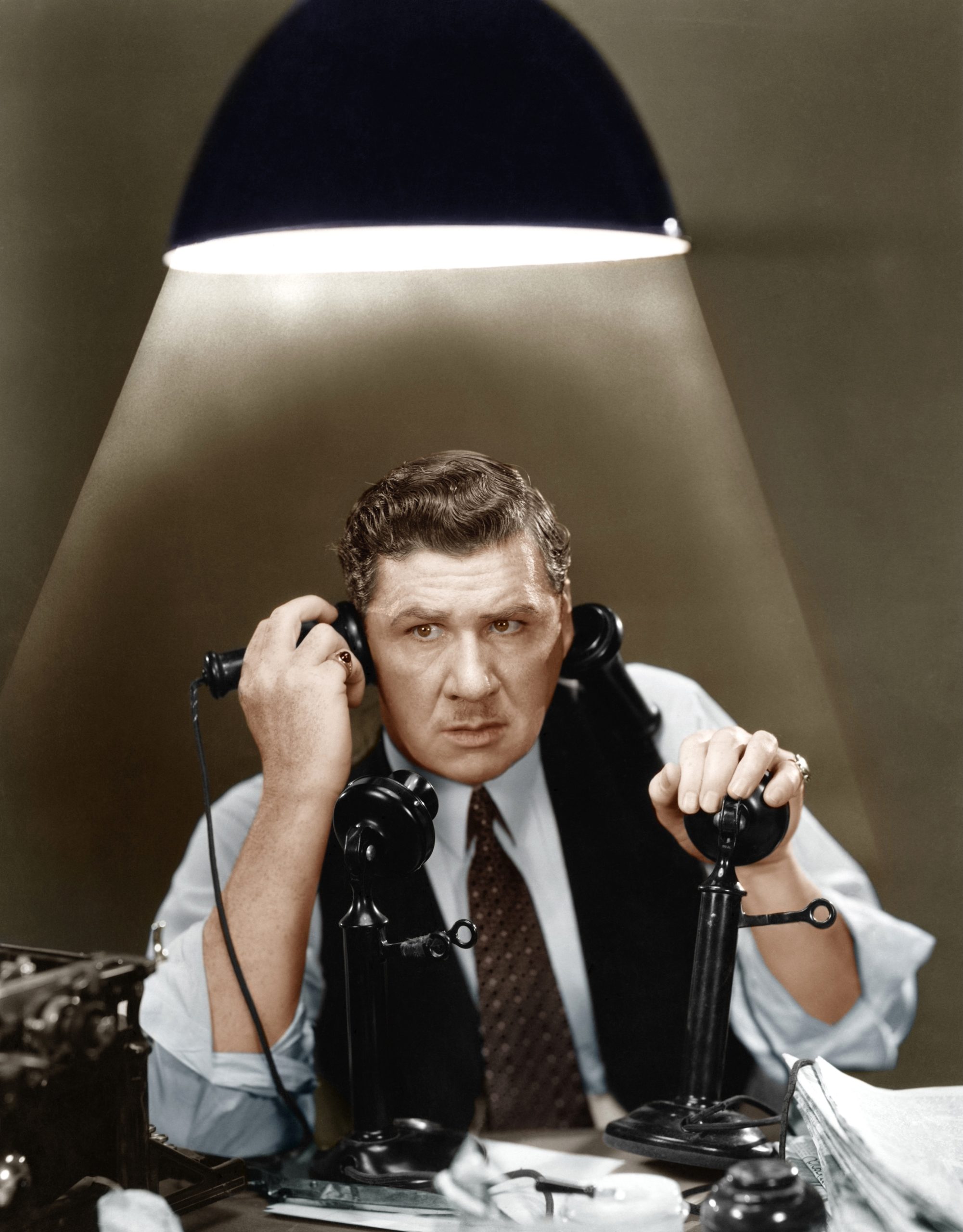 Man using two telephones  (All persons depicted are not longer living and no estate exists. Supplier warranties that there will be no model release issues.)